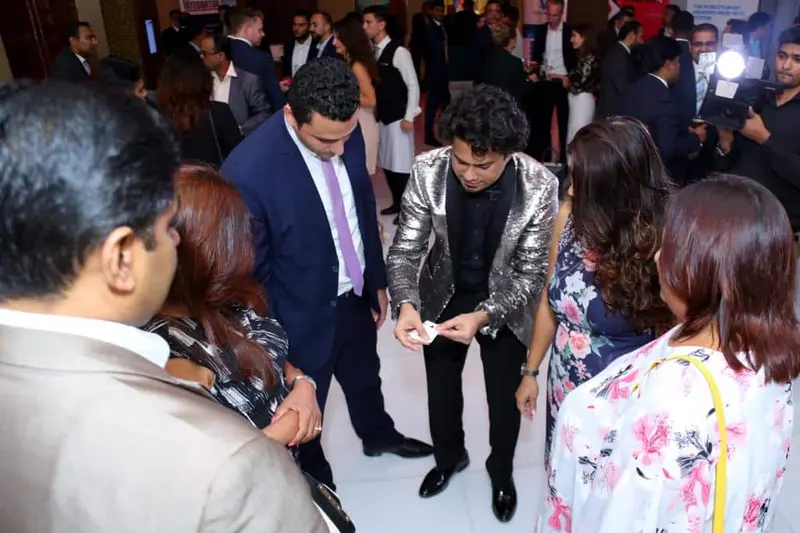 Roaming magician doing card magic for a group of guests at an evening event